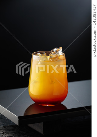 Cocktail Tequila sunrise on a black table in bar. Cocktail Tequila sunrise on a black table in bar. 142382417