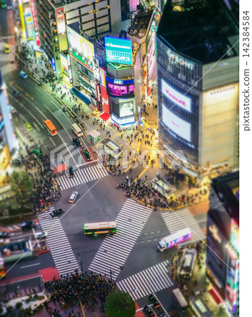 The Shibuya scramble crossing and the bustling downtown area at night The Shibuya scramble crossing and the bustling downtown area at night 142384584