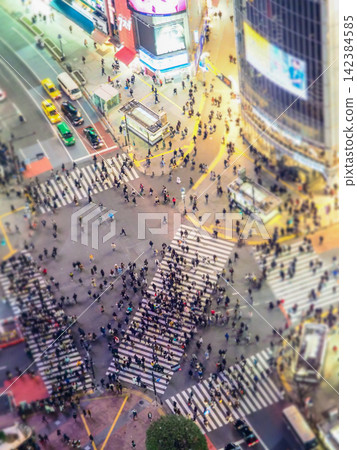 The Shibuya scramble crossing and the bustling downtown area at night The Shibuya scramble crossing and the bustling downtown area at night 142384585