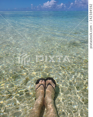 Relaxing feet in the clear waters of a tropical sea Relaxing feet in the clear waters of a tropical sea 142384592