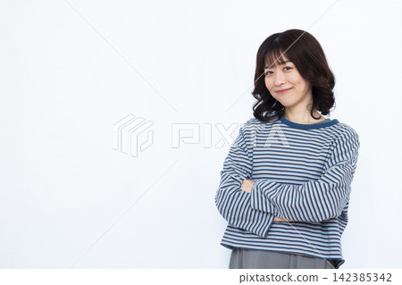 A woman thinking with her arms folded A woman thinking with her arms folded 142385342