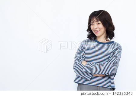 A woman thinking with her arms folded A woman thinking with her arms folded 142385343