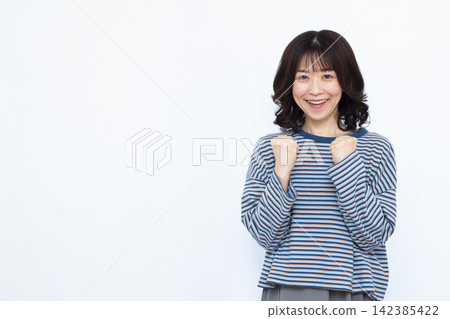 A woman doing a guts pose with a smile A woman doing a guts pose with a smile 142385422
