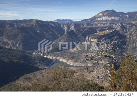 Serene mountain valley landscape with river under blue sky Serene mountain valley landscape with river under blue sky 142385424