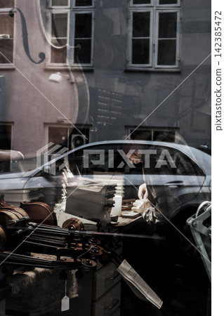 Luthier crafting violin in workshop reflecting city life Luthier crafting violin in workshop reflecting city life 142385472