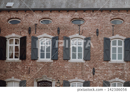 Ancient castle window with wooden shutters, European historic architecture. Medieval castle interior window with traditional shutters and rustic details 142386056