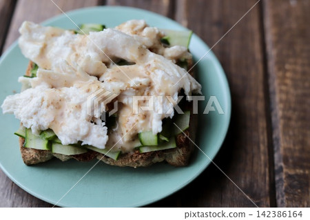 全麥麵包夾黃瓜片和鮮嫩鹹香的米曲雞肉,佐以芝麻醬。 全麥麵包夾黃瓜片和鮮嫩鹹香的米曲雞肉,佐以芝麻醬。 142386164