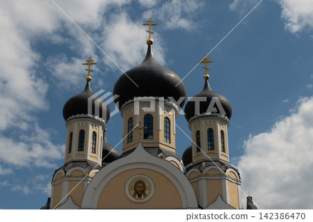 a monastery with three domes against a blue sky a monastery with three domes against a blue sky 142386470