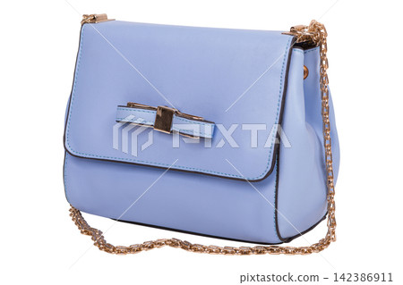 Light blue leather womens crossbody bag with gold chain strap isolated on white background. Small bow handbag side view Light blue leather womens crossbody bag with gold chain strap isolated on white background. Small bow handbag side view 142386911