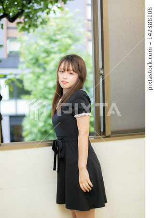 Summer outfit: Girl in a black dress at a resort. Summer outfit: Girl in a black dress at a resort. 142388108