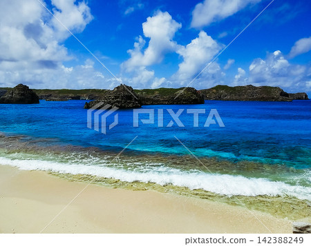 [World Natural Heritage Site - Ogasawara Islands] Ginny Beach with its white sand and Minami Island floating offshore, under a clear blue sky (4:3) 142388249