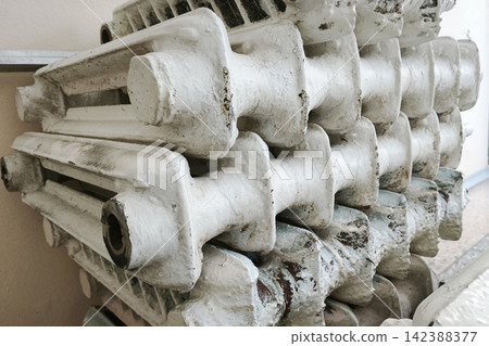 Stacked dismantled radiators ready for replacement, symbolizing heating system modernization, energy efficiency, heat conservation, and winter preparation. Stacked dismantled radiators ready for replacement, symbolizing heating system modernization, energy efficiency, heat conservation, and winter preparation. 142388377