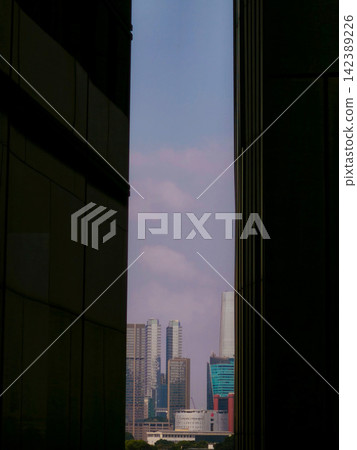 Low-angle view of modern glass skyscrapers and high-rise commercial office towers against the sky in the central business district of Jakarta, Indonesia. Low-angle view of modern glass skyscrapers and high-rise commercial office towers against the sky in the central business district of Jakarta, Indonesia. 142389226