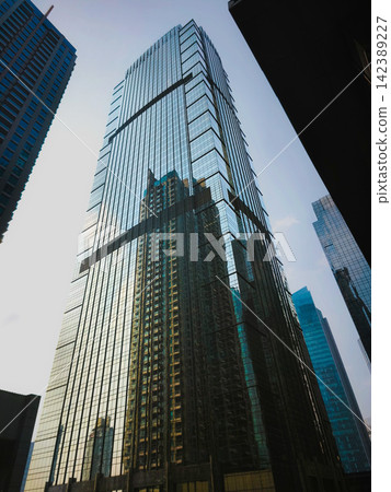 Low-angle view of modern glass skyscrapers and high-rise commercial office towers against the sky in the central business district of Jakarta, Indonesia. Low-angle view of modern glass skyscrapers and high-rise commercial office towers against the sky in the central business district of Jakarta, Indonesia. 142389227