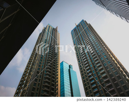 Low-angle view of modern glass skyscrapers and high-rise commercial office towers against the sky in the central business district of Jakarta, Indonesia. Low-angle view of modern glass skyscrapers and high-rise commercial office towers against the sky in the central business district of Jakarta, Indonesia. 142389240