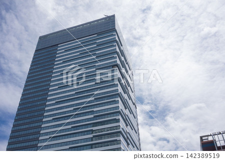 The view of Toyosu Bayside Cross Tower is striking, with a clear blue sky contrasting beautifully with the modern architecture. The view of Toyosu Bayside Cross Tower is striking, with a clear blue sky contrasting beautifully with the modern architecture. 142389519