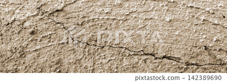 A rough, sandy, tan-beige concrete surface with diagonal cracks. A rough, sandy, tan-beige concrete surface with diagonal cracks. 142389690