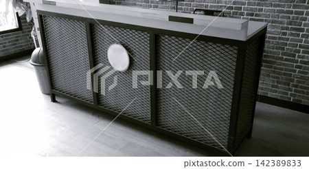 Industrial style black metal reception desk with mesh panels for a cafe interior. 142389833
