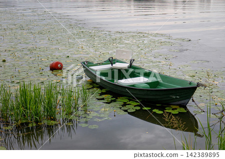 Green boat on the lake Green boat on the lake 142389895