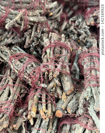 Bundles of tree bark wrapped with red string for herbal or natural craft use background Bundles of tree bark wrapped with red string for herbal or natural craft use background 142389928