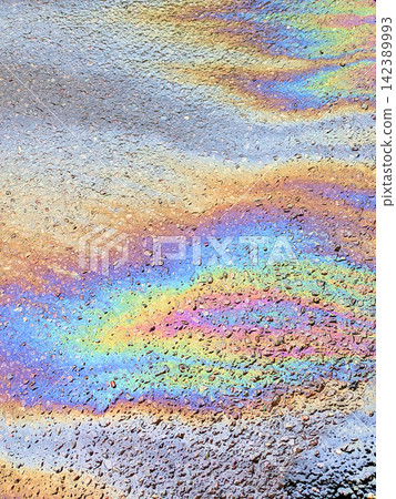 A leaked Car Oil Petrol in The Rain on a Tarmac Road Metallic Rainbow Gasoline A leaked Car Oil Petrol in The Rain on a Tarmac Road Metallic Rainbow Gasoline 142389993