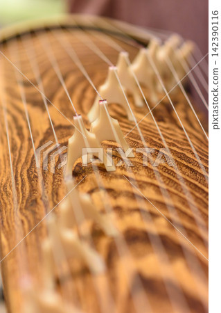 A close-up photograph of the intricate details of a traditional Chinese guqin A close-up photograph of the intricate details of a traditional Chinese guqin 142390116