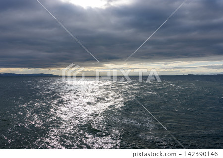 A vast, dynamic seascape under an overcast sky viewed from water's edge A vast, dynamic seascape under an overcast sky viewed from water's edge 142390146