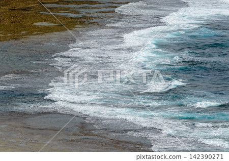 A dynamic coastal scene featuring continuous wave motion from a viewpoint emphasizing interaction between sea and shoreline A dynamic coastal scene featuring continuous wave motion from a viewpoint emphasizing interaction between sea and shoreline 142390271