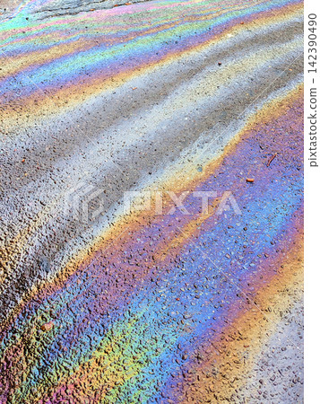 A leaked Car Oil Petrol in The Rain on a Tarmac Road Metallic Rainbow Gasoline A leaked Car Oil Petrol in The Rain on a Tarmac Road Metallic Rainbow Gasoline 142390490