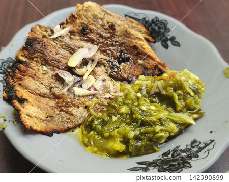 Authentic Indonesian Dendeng Cabe Ijo, crispy fried beef slices topped with savory coarse green chili sambal Authentic Indonesian Dendeng Cabe Ijo, crispy fried beef slices topped with savory coarse green chili sambal 142390899