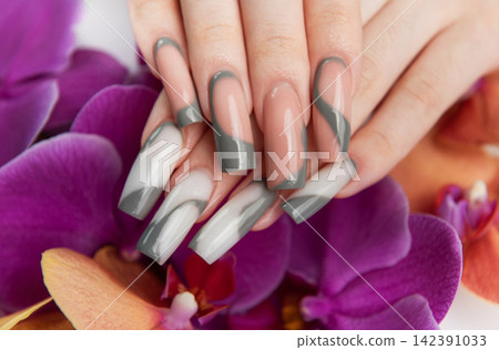 Woman's hand showing modern gray french manicure design 142391033