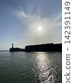暮色漸濃，海灘上的燈塔隱約可見。 142391149