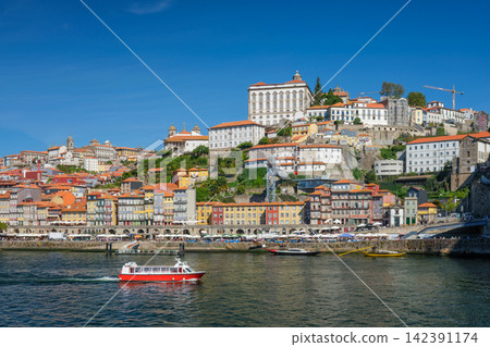 Tourist boat crossing Douro River below Ribeira Porto Tourist boat crossing Douro River below Ribeira Porto 142391174