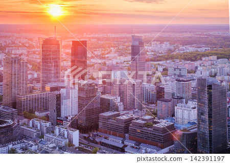 Dense Warsaw skyline at sunset with dramatic sky over Poland skyscrapers Dense Warsaw skyline at sunset with dramatic sky over Poland skyscrapers 142391197