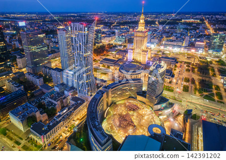 Warm-lit Warsaw Palace of Culture landmark skyline at blue hour in Poland 142391202