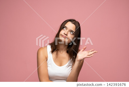 Young woman shrugging, doubt and confusion on her face, looking sideways and up. Copy space for text Young woman shrugging, doubt and confusion on her face, looking sideways and up. Copy space for text 142391676