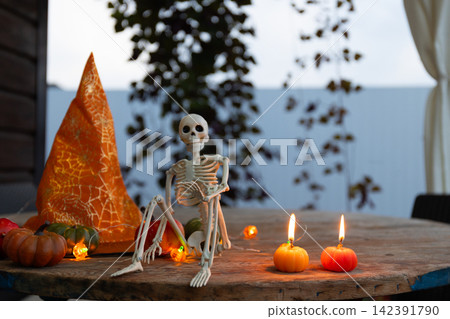 Cozy Halloween Veranda Decor: Skeleton, Pumpkins and Candlelit Autumn Evening Cozy Halloween Veranda Decor: Skeleton, Pumpkins and Candlelit Autumn Evening 142391790