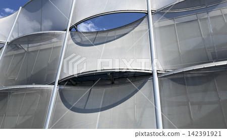 Modern facade with curved mesh panels Modern facade with curved mesh panels 142391921