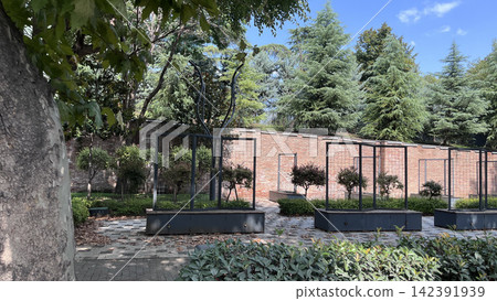 Empty garden with brick wall and metal planters Empty garden with brick wall and metal planters 142391939