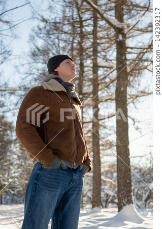 Young man enjoying sunny winter day outdoors Young man enjoying sunny winter day outdoors 142392317