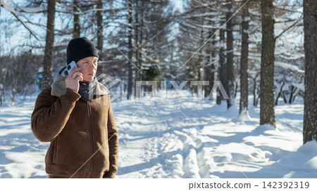 Man talking on smartphone in winter park with copy space Man talking on smartphone in winter park with copy space 142392319