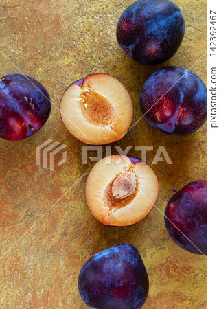 plums scattered on the table, fresh, top view, yellow-orange background, no people, plums scattered on the table, fresh, top view, yellow-orange background, no people, 142392467