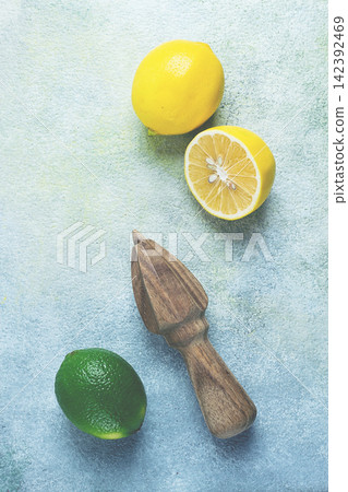 Wooden citrus reamer, manual lemon juicer, made of acacia wood, with citrus fruits on the table, top view, Wooden citrus reamer, manual lemon juicer, made of acacia wood, with citrus fruits on the table, top view, 142392469