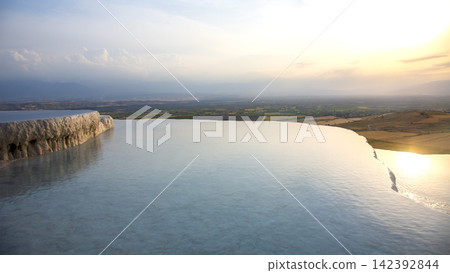 Sunset at Pamukkale in Turkey overlooking terraced pools and fields 142392844