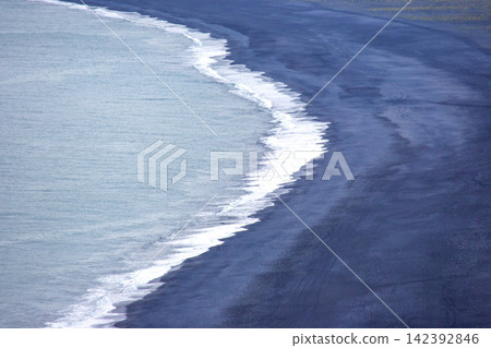 Waves meet the black sand beach in Iceland during a cloudy day Waves meet the black sand beach in Iceland during a cloudy day 142392846