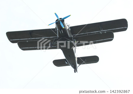 Plane flies overhead in clear sky during daytime Plane flies overhead in clear sky during daytime 142392867