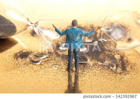Miniature people standing among broken glass and spilled sand in a creative scene Miniature people standing among broken glass and spilled sand in a creative scene 142392967
