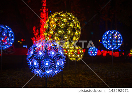 Colorful light displays in a park during a night event Colorful light displays in a park during a night event 142392971
