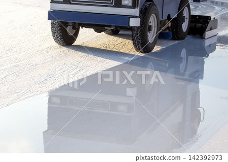 Ice resurfacing machine works on rink during afternoon in outdoor location 142392973