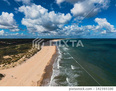 High angle wide horizontal aerial drone photograph of sandy beach, coastal sand dunes, North Sea waves, and cumulus clouds in Neeltje Jans, Zeeland, Netherlands on sunny summer day High angle wide horizontal aerial drone photograph of sandy beach, coastal sand dunes, North Sea waves, and cumulus clouds in Neeltje Jans, Zeeland, Netherlands on sunny summer day 142393100